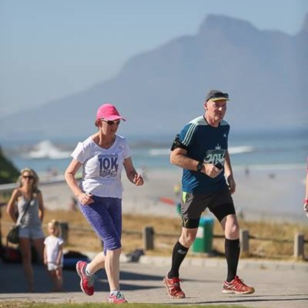 Joanne & Tony running along a beach in Cape Town